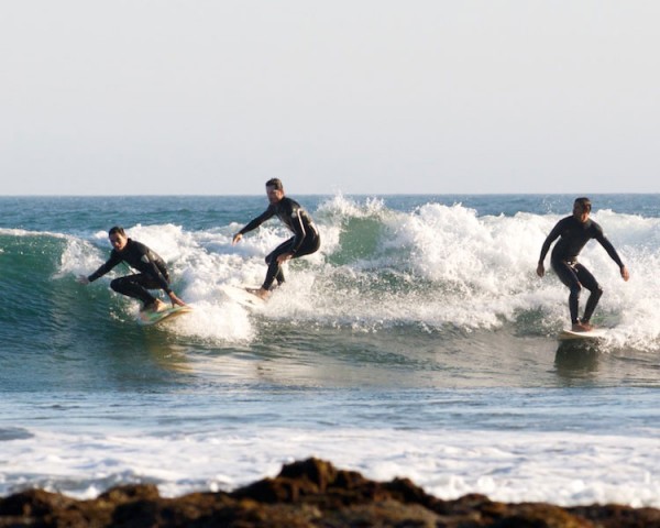 Three surfers competing for the wave