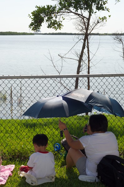 My son and wife sitting under umbrellas waiting for the launch My son and wife sitting under umbrellas waiting for the launch